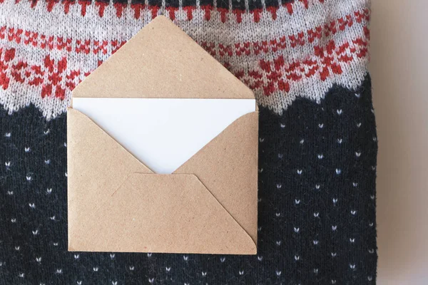 Ambachtelijke papieren enveloppe met lege witte wenskaart op Kerstmis — Stockfoto
