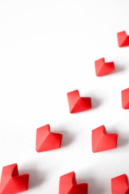 Red paper origami hearts diagonals on white background