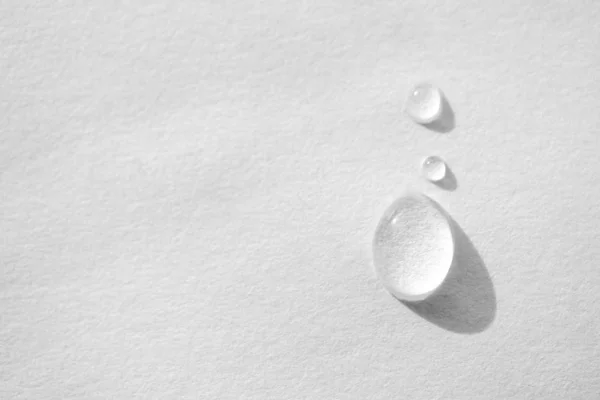 Water drop on white paper textured background with copy space an — Stock Photo, Image