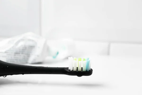 Electric toothbrush and tube with toothpaste on background, clos — Stock Photo, Image