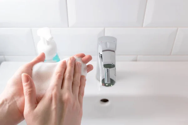 Lavar as mãos com espuma de sabão suave sobre a pia no banheiro — Fotografia de Stock