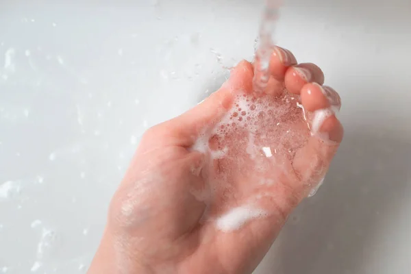 Tvätt handen över diskbänken i badrummet under vattenbäcken wi — Stockfoto