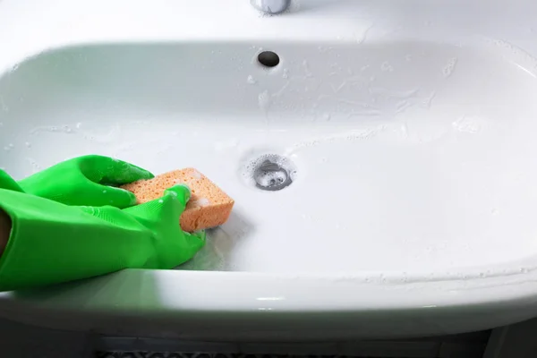 Händer i grönt gummi handskar ren diskbänk i inhemska badrum gurka — Stockfoto