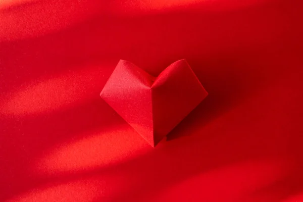 Origami heart on red paper background with trendy shadow. Minima — Stock Photo, Image