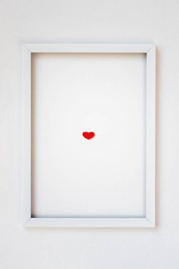 Küçük kırmızı ahşap süslemeli kalp beyaz çerçeveli sırt.