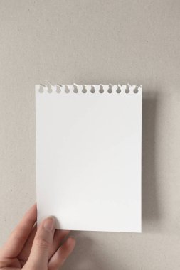Kadın eli, yırtık beyaz boş bir defter kağıdı sayfası