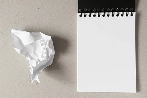 Cuaderno abierto con hoja de papel blanco en blanco y ba de papel arrugado — Foto de Stock