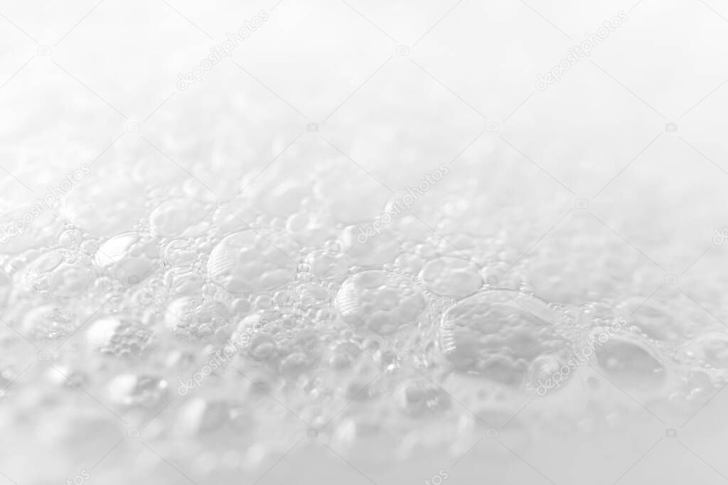 Close-up foam bubbles with selective focus from soap, shampoo or cleanser on white background. Macro