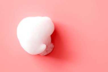 Sabundan beyaz köpük lekesi, pembe arka planda şampuan ya da temizleyici seçici odaklı. Yakın çekim, makro