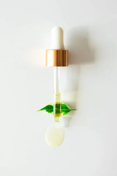 Serum Szklanej Pipecie Olej Nawilżający Kropla Zielonym Liście Roślin Białym — Zdjęcie stockowe