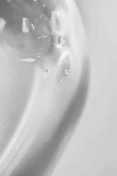 Cam petri kabındaki şeffaf aloe jeli beyaz arka planda dikey lekeler. Laboratuvar testlerini ve araştırmalarını kabul et. Saf yüz temizleyici, kabuk soyucu, şampuan veya duş jeli.