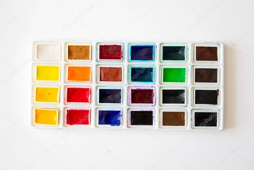 Colorful watercolor palette box on white background, top view. Concept creative and art