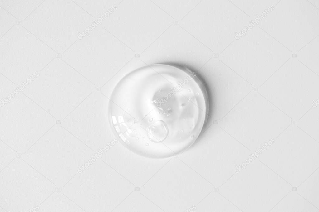 Aloe gel smudge with air bubbles on white background. Pure transparent facial cleanser, peeling, shampoo or shower gel, top view