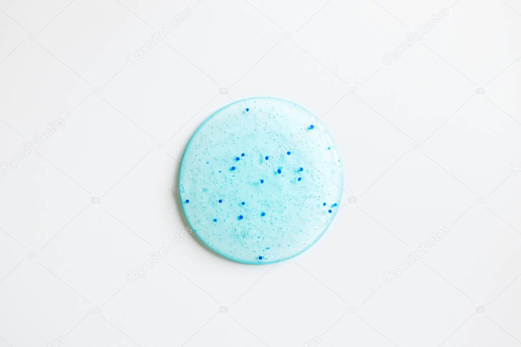 Round body scrub spot on white background, top view. Close-up texture peeling cosmetic product. Beauty skin care treatment