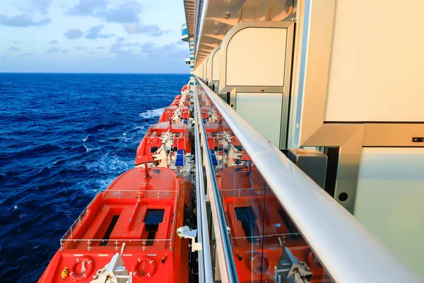 Line ship side with lifeboats and balcony staterooms on cruise ship