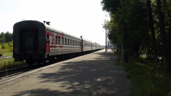 Tåget lämnar stationen järnvägsstationen, plattform. — Stockfoto