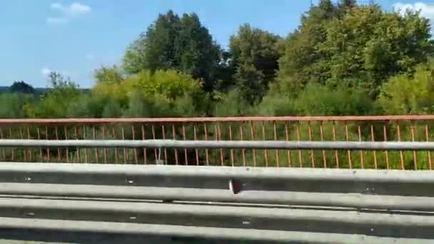 De brug over de rivier. Wegbrug langs de oever van de rivier. — Stockvideo