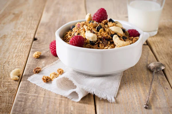 Healthy breakfast with oats granola,raspberry and nuts over wood