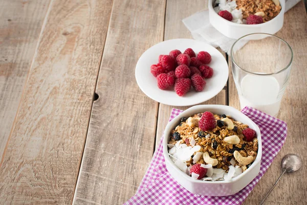 Healthy breakfast with oats granola,raspberry and nuts over wood