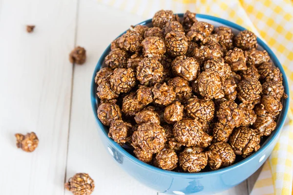 Pop-corn au caramel chocolat dans une tasse sur une table en bois blanc — Photo