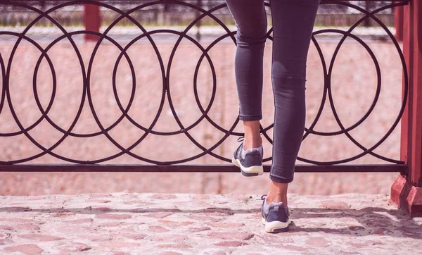 Молодые девушки в джинсах и кроссовках спортивная обувь ходить по дороге — стоковое фото