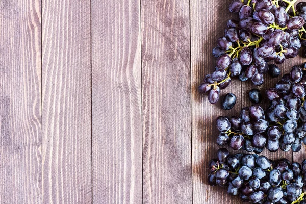 Koyu ahşap arka plan üzerinde siyah üzüm şube