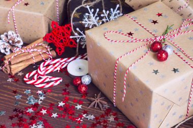 Noel tatil hediye kutusu çam kozalakları tarçın ile dekore edilmiş şenlikli tabloda baston fındık candy ve yıldız ahşap zemin üzerine ışıltı