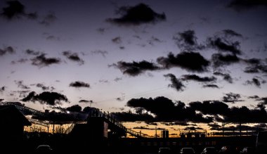 Gün batımında istasyon. Demiryolu üzerindeki köprü..