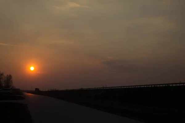 Puesta Sol Cerca Carretera Gran Sol Rojo Atardecer Coches Sobre — Foto de Stock