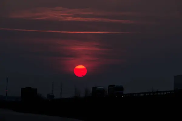 道路の近くの日没 日没の大きな赤い太陽 — ストック写真