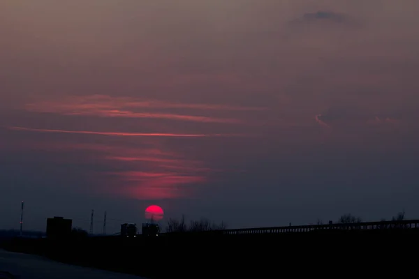 道路の近くの日没 日没の大きな赤い太陽 — ストック写真