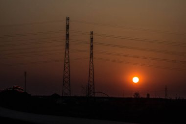 Yolun ve antenlerin arka planında gün batımı. Güzel manzara. Arkaplan.