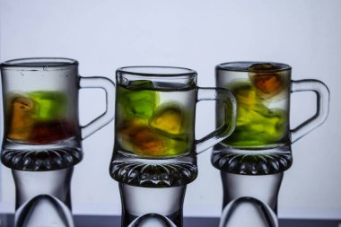 Sıra dışı bir kokteyl. Bardakta iç. Cama vuran güneş. Ateş kokteyli. Arkaplan.