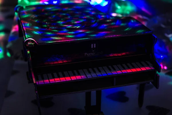 在黑暗的背景下 灯光下的钢琴 钢琴上的鸡尾酒 — 图库照片