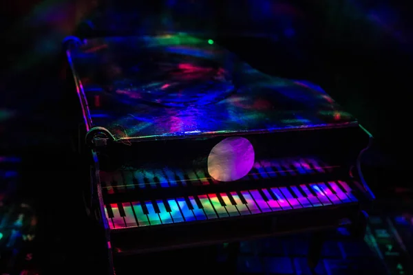 Lambaların ışığında karanlık bir arka planda piyano. Yakın plan. Arkaplan.
