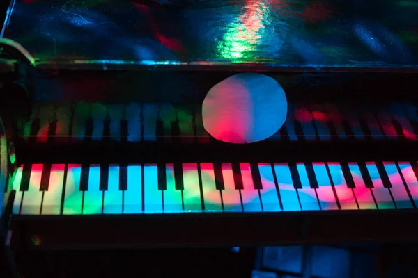 Piano on a dark background in the light of lamps. Close-up. Background.