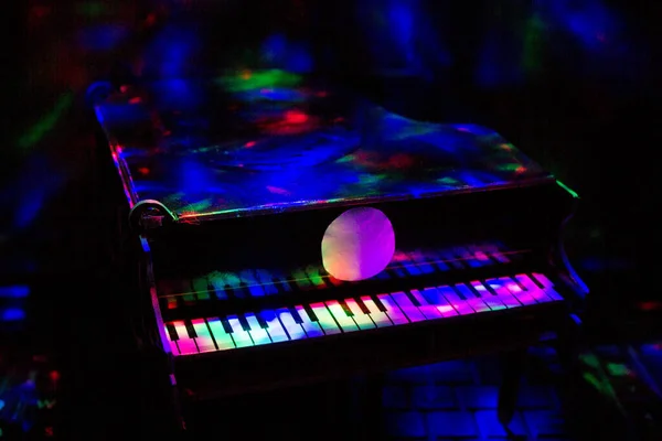 Piano on a dark background in the light of lamps. Close-up. Background.