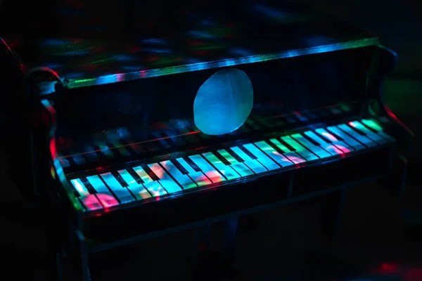 Piano on a dark background in the light of lamps. Close-up. Background.