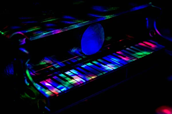Lambaların ışığında karanlık bir arka planda piyano. Yakın plan. Arkaplan.