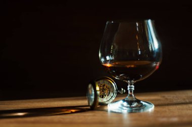 Vintage iskelet saatin yanındaki masada cam konyak ile standları.