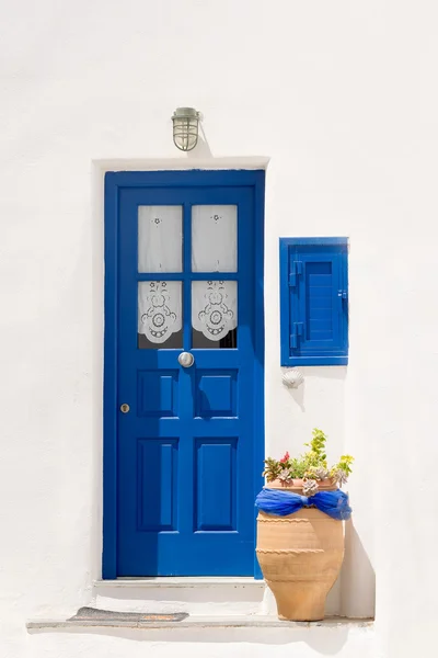 Bella porta blu con una pentola fuori all'isola di Paros in Grecia. Cicladi tradizionali fuori da una casa . — Foto Stock