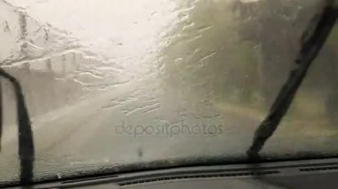 Şiddetli yağmur ve dolu şehirde sürüş sırasında. Arabanın içindeki ilk person kamera.