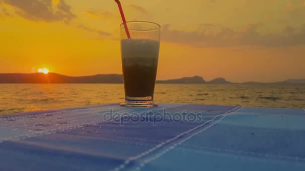 Café gelado contra o pôr do sol . — Vídeo de Stock