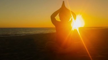 Güzel bir gün batımı karşı yoga yaparken kadının siluet.