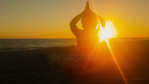 Frauensilhouette beim Yoga vor einem schönen Sonnenuntergang. — Stockvideo