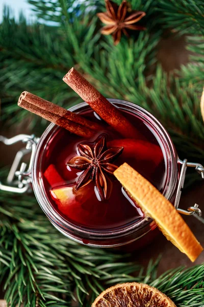 Mulled wine in a glass. Christmas hot mulled wine in a glass with spices and citrus fruit. Mulled wine with cinnamon, anise and orange. Christmas atmosphere