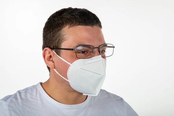 Koruyucu maske takan gözlüklü bir adam.
