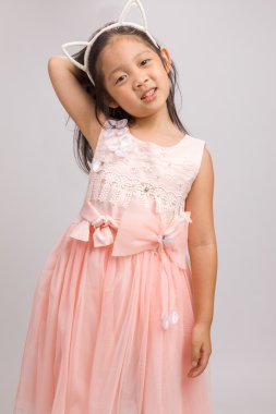 Kedi kulak bandı üzerinde beyaz izole pembe elbiseli olan çocuk