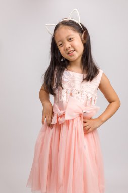 Kedi kulak bandı üzerinde beyaz izole pembe elbiseli olan çocuk