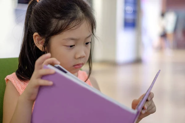 Livro de leitura de criança asiática na biblioteca — Fotografia de Stock